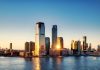 Breathtaking sunrise view over New York City skyline with reflection on the water.