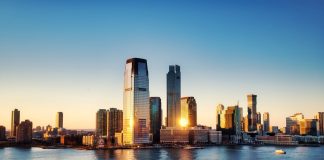 Breathtaking sunrise view over New York City skyline with reflection on the water.