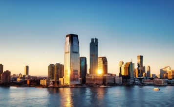 Breathtaking sunrise view over New York City skyline with reflection on the water.