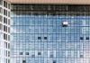 High-rise glass building exterior with window cleaners in Hamburg, Germany.