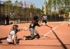 A dynamic moment during a women's softball game with the batter hitting the ball.