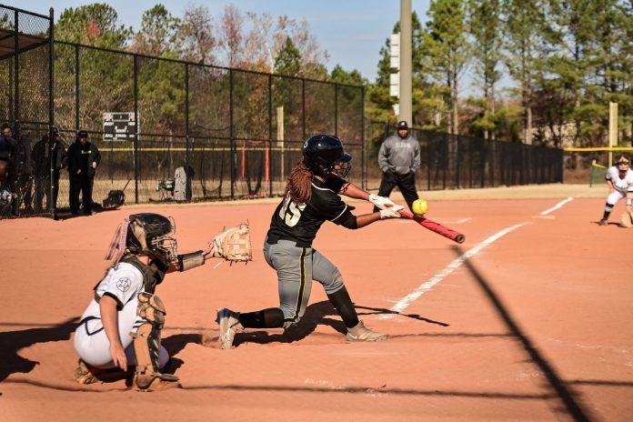 ltima-hora-copa-de-softbol-rabbit-mart-nez-celebr A dynamic moment during a women's softball game with the batter hitting the ball.