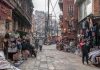 Street view of a lively market in Kathmandu, Nepal with vendors and shoppers.
