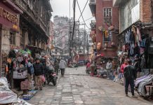 Street view of a lively market in Kathmandu, Nepal with vendors and shoppers.