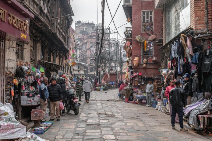 Street view of a lively market in Kathmandu, Nepal with vendors and shoppers.