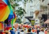 ÚLTIMA HORA: Feria All About Downtown Street Fair regresa a Jersey City Colorful rainbow umbrellas adorn a lively outdoor city festival with a bustling crowd.
