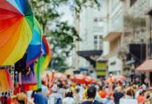 ÚLTIMA HORA: Feria All About Downtown Street Fair regresa a Jersey City Colorful rainbow umbrellas adorn a lively outdoor city festival with a bustling crowd.