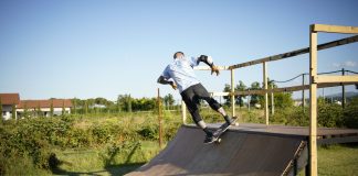 ÚLTIMA HORA: Shred.Co, programa de skate adaptado cerca de Hoboken Skateboarder executing a trick on a wooden outdoor skate ramp with lush greenery in the background.