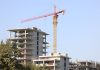 Concrete high-rise building under construction with a tower crane in Uzbekistan.