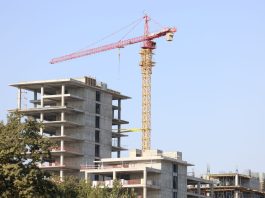 ÚLTIMA HORA: Venta de terreno en Marion abre paso a torre de 321 unidades Concrete high-rise building under construction with a tower crane in Uzbekistan.