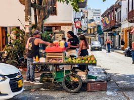 Vibrant street market scene with a fruit vendor in Cartagena, Colombia's historic district.