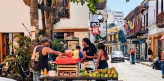 Vibrant street market scene with a fruit vendor in Cartagena, Colombia's historic district.