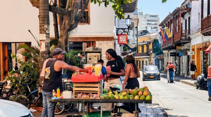 Vibrant street market scene with a fruit vendor in Cartagena, Colombia's historic district.