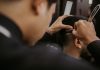Las Mejores Barberías y Salones en Union City, NJ (2026): Guía Local Completa Close-up of a barber expertly styling a man's hair with a razor and comb in a trendy barbershop.