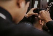Las Mejores Barberías y Salones en Union City, NJ (2026): Guía Local Completa Close-up of a barber expertly styling a man's hair with a razor and comb in a trendy barbershop.