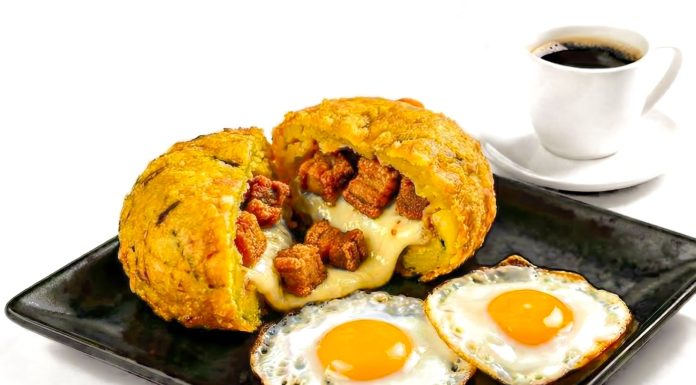 Los Mejores Desayunos en West New York: Guía 2026 para Empezar el Día Delicious Ecuadorian breakfast featuring mote pillo, fried eggs, and coffee on a black plate.