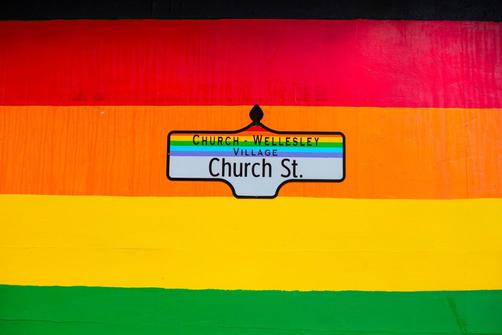 Vibrant Church Street sign in Toronto's Church-Wellesley Village with rainbow colors.