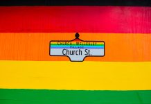 Vibrant Church Street sign in Toronto's Church-Wellesley Village with rainbow colors.
