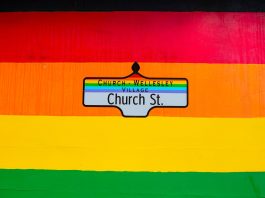 Vibrant Church Street sign in Toronto's Church-Wellesley Village with rainbow colors.