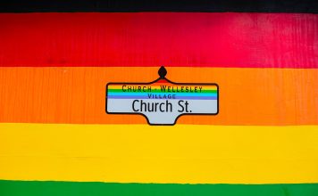 Vibrant Church Street sign in Toronto's Church-Wellesley Village with rainbow colors.