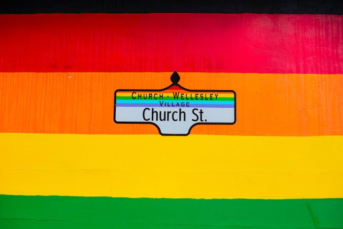 Vibrant Church Street sign in Toronto's Church-Wellesley Village with rainbow colors.