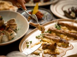 Los Mejores Restaurantes en Jersey City Ahora Mismo (Guía 2026) Close-up of a gourmet meal with diverse dishes, showcasing fine dining and sophisticated presentation.