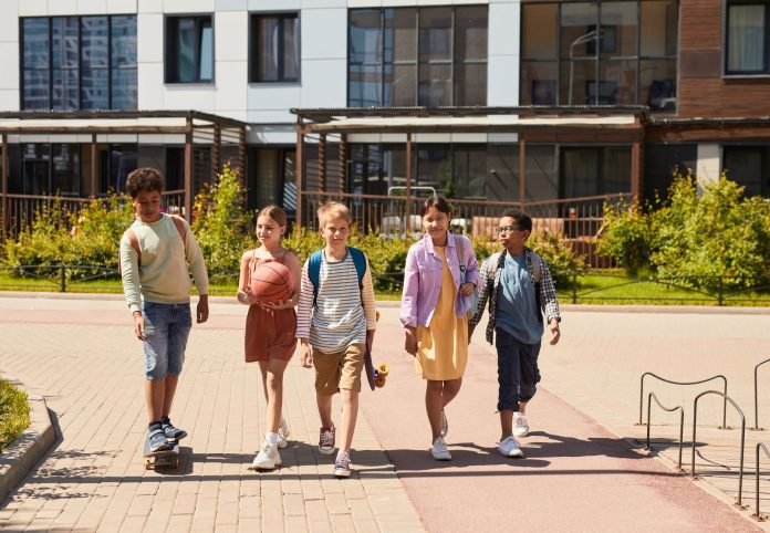 programas-despues-escuela-west-new-york-2026 A diverse group of children walking outdoors, symbolizing friendship and multicultural unity.