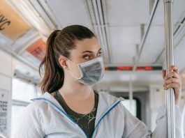 Public Transportation West New York NJ: Your Complete 2026 Commuter Guide An adult woman wearing a face mask rides public transportation, focusing on safety and protection.