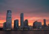 Stunning view of New York City skyline with a vibrant sunset reflecting on skyscrapers.