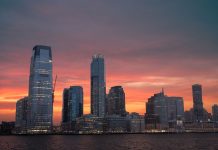 Stunning view of New York City skyline with a vibrant sunset reflecting on skyscrapers.
