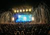 Dynamic live music concert with vibrant stage lights and a lively crowd enjoying the night.