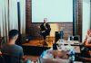Stevens and Harvard Bring Educators’ Conference to Jersey City A business seminar with a speaker addressing an attentive audience in a modern conference setting.