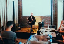 Stevens and Harvard Bring Educators’ Conference to Jersey City A business seminar with a speaker addressing an attentive audience in a modern conference setting.