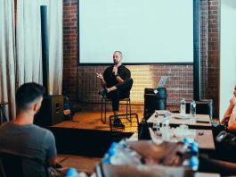 A business seminar with a speaker addressing an attentive audience in a modern conference setting.