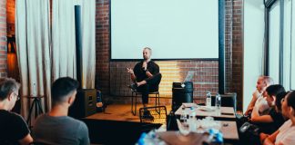 A business seminar with a speaker addressing an attentive audience in a modern conference setting.