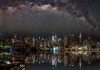 Nighttime view of New York City with stars reflecting on the water.