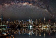 Nighttime view of New York City with stars reflecting on the water.