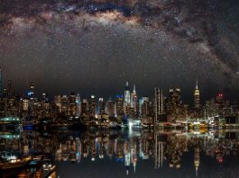 Nighttime view of New York City with stars reflecting on the water.