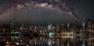 Nighttime view of New York City with stars reflecting on the water.