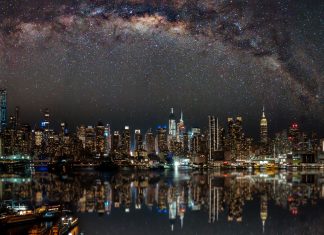 Nighttime view of New York City with stars reflecting on the water.