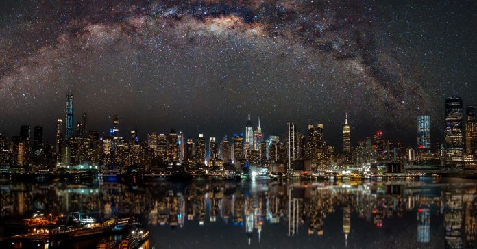 Nighttime view of New York City with stars reflecting on the water.